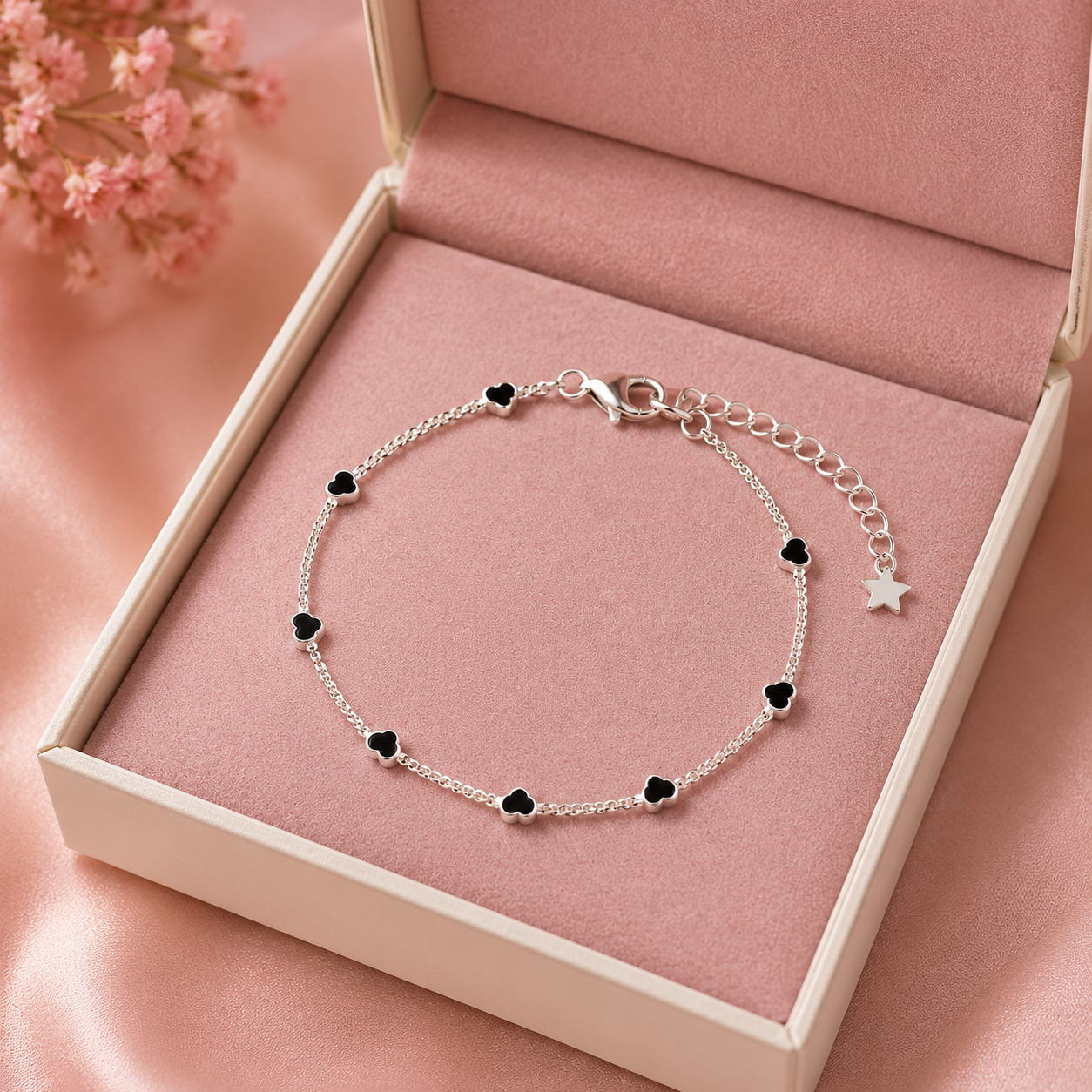 Pulseira infantil com corações acompanhada de saquinho de veludo rosa.