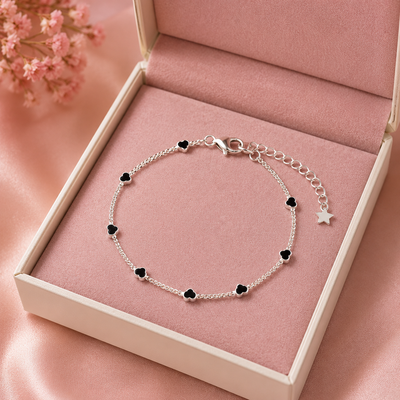 Pulseira infantil com corações acompanhada de saquinho de veludo rosa.