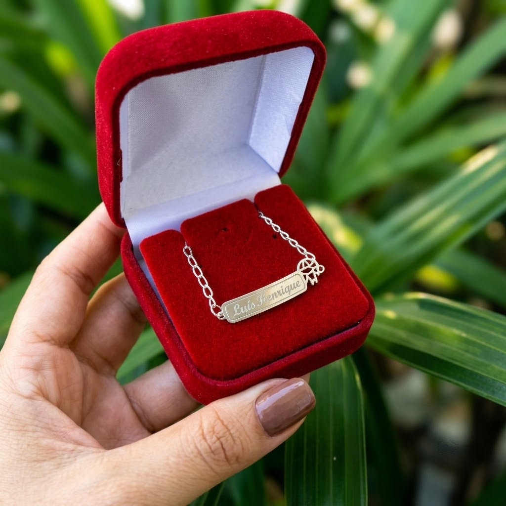 Pulseira de prata legítima com nome gravado na plaquinha, sendo usada no pulso de uma criança.